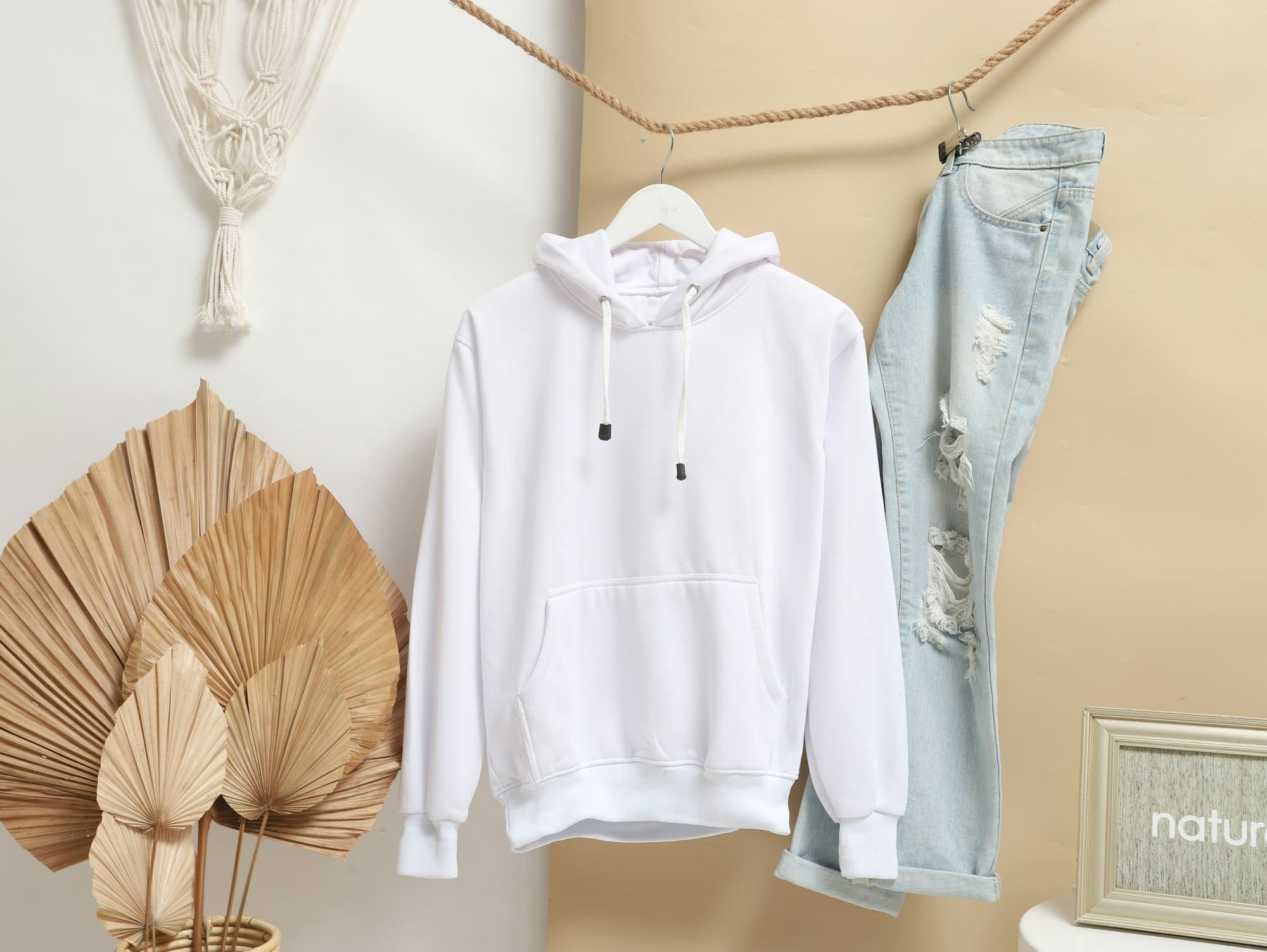 Blank premium white hoodie on hanger showing fabric quality and construction for custom clothing manufacturing